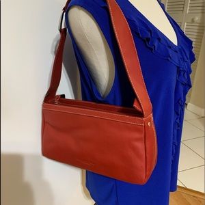 New red leather, with top zipper. Size 11L x 6Hx 3W.